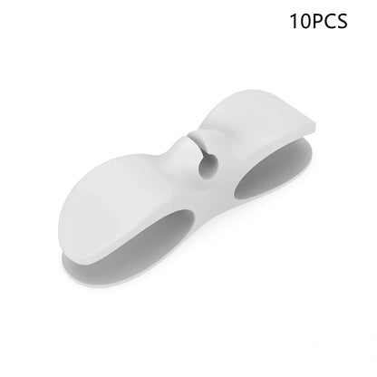 Black TPU cable organizer clips winding appliance cords on kitchen counter, 5cm size, non-marking adhesive for tidy management