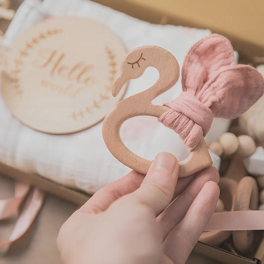Six wooden animal bath toys floating in water with blue, brown and peach colour options
