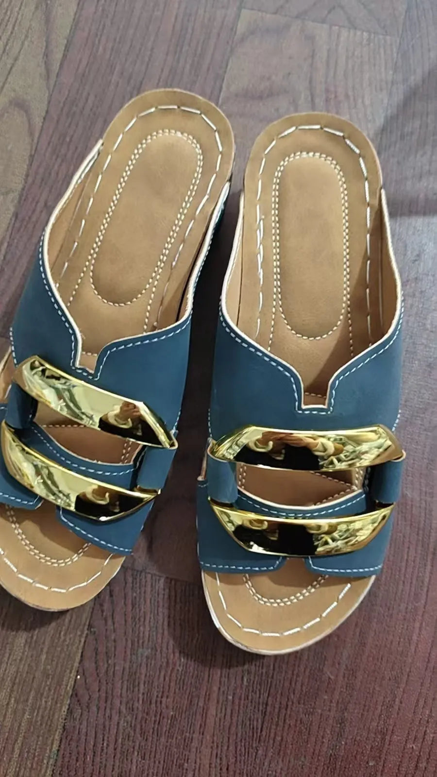 Roman style platform sandals in black with a flat heel and metal detail on the strap.