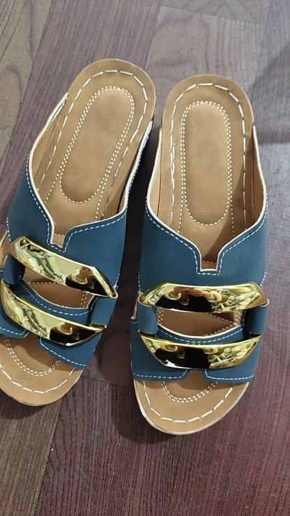 Roman style platform sandals in black with a flat heel and metal detail on the strap.