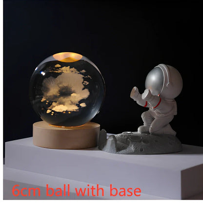 3D crystal ball night light projecting solar system pattern on wooden base with astronaut figurine