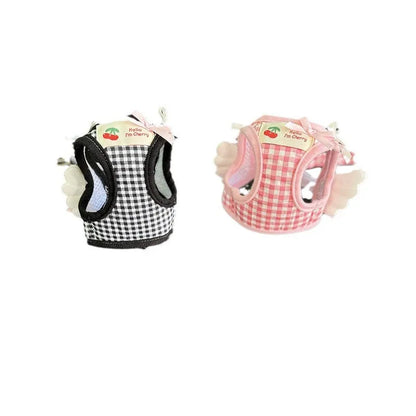 Small dog wearing adjustable cotton harness in pink with chest-back design and hand holding rope attachment