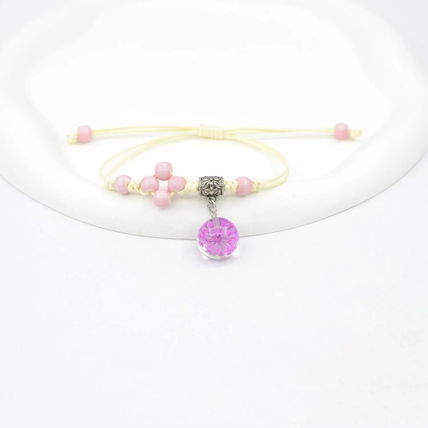Hand-woven glass bracelet with large 1.4 cm beads containing real dried flowers, shown in blue.