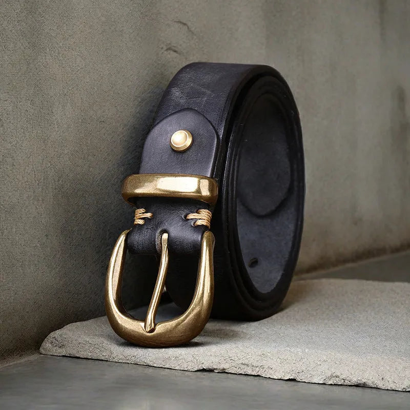 Men's black genuine cattlehide leather belt with a copper pin buckle on a jeans background.