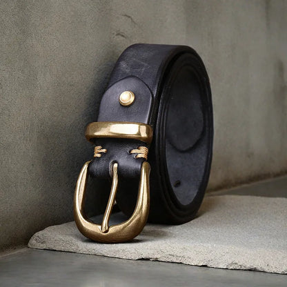 Men's black genuine cattlehide leather belt with a copper pin buckle on a jeans background.