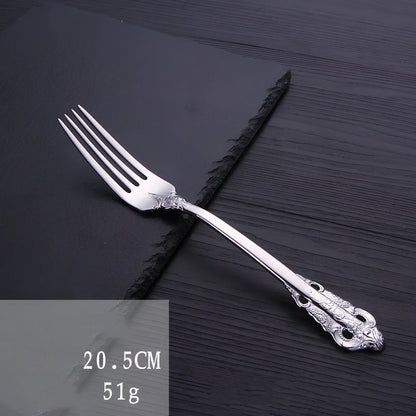 Four-piece stainless steel cutlery set showing main knife, fork, spoon, and teaspoon with mirror finish