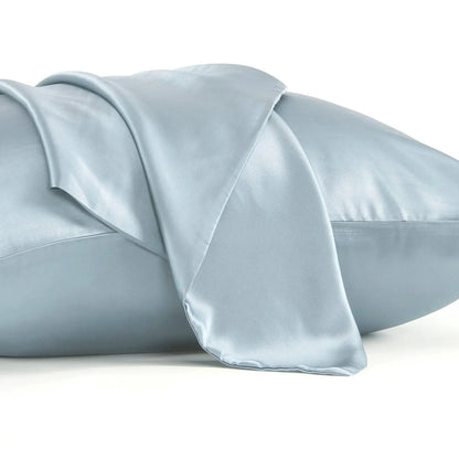 Dark grey silk pillowcase with envelope closure on a bed.