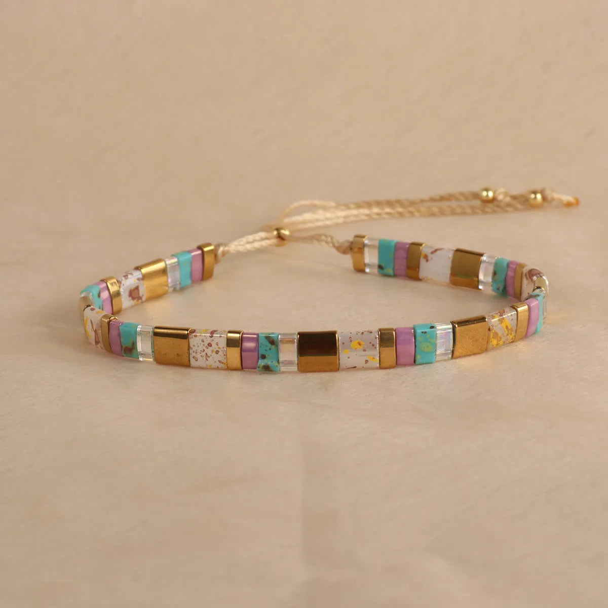 Adjustable pull beads glass bracelet in geometric shapes, shown in milky white colour.