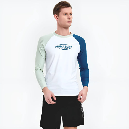Man wearing a white long-sleeve swim top and matching coloured double-layer swim trunks on the beach.