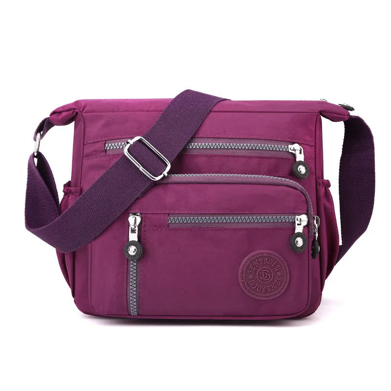 Soft grey nylon messenger bag with a single shoulder strap, shown in a square vertical shape.