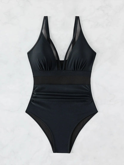 Black halter neck one-piece swimsuit with mesh panels, shown on a model.