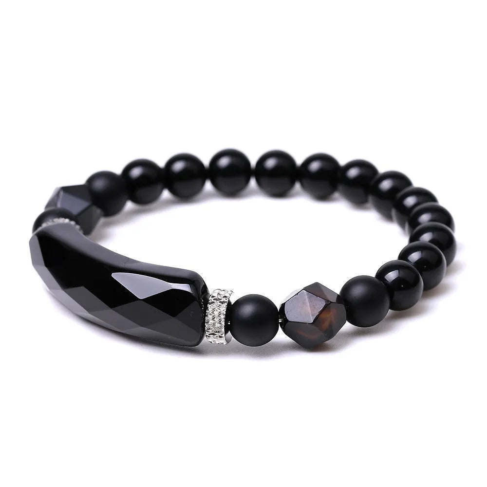Handmade diamond-shaped cut black agate bracelet with fan-shaped details on a wrist.