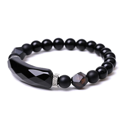 Handmade diamond-shaped cut black agate bracelet with fan-shaped details on a wrist.