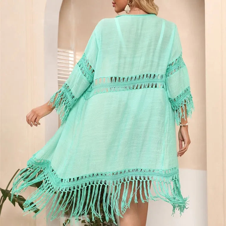 Yellow hand crocheted beach cover-up cardigan with tassel stitching on a mannequin