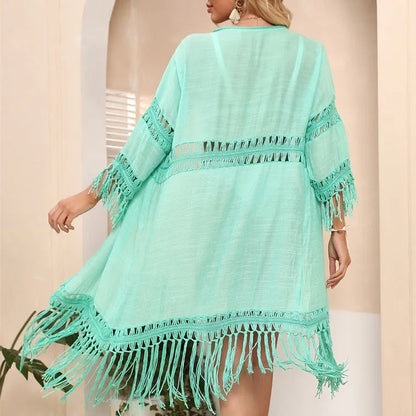 Yellow hand crocheted beach cover-up cardigan with tassel stitching on a mannequin