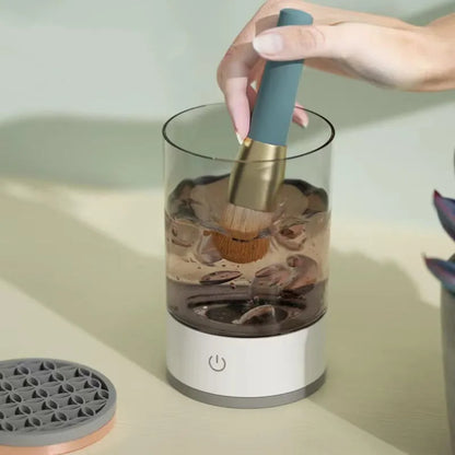 Grey and white portable electric makeup brush cleaner with USB charging cable.