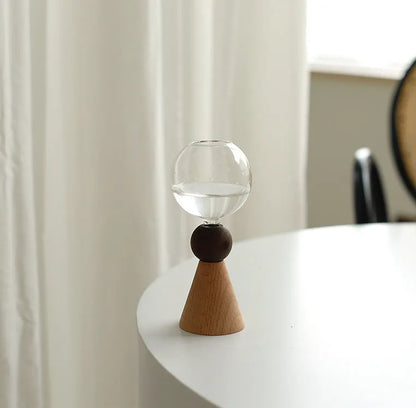 Geometric clear glass bubble vase on wooden base showing conical and arc bottom style options