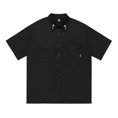 Man wearing a black cotton blend half-sleeve loose fit work shirt with embroidered detail.