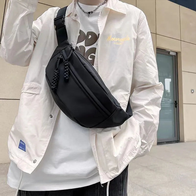 Men's polyester crossbody bag in black colour showing shoulder strap and front compartment