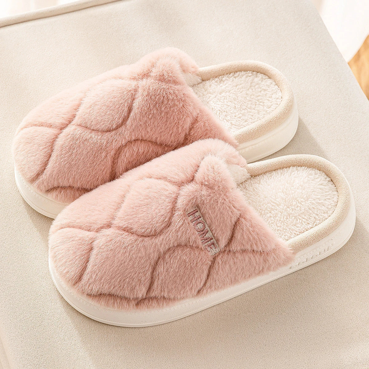 Cozy plush slippers in various colors, including light gray, khaki, yellow, and pink, with a soft plush upper and durable PVC sole for indoor and outdoor use.