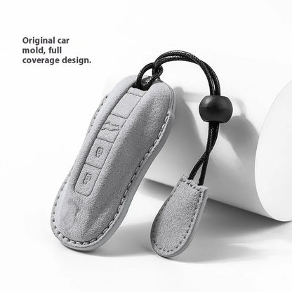 Suede car key cover in cement grey, dark green, light grey, and orange colour options