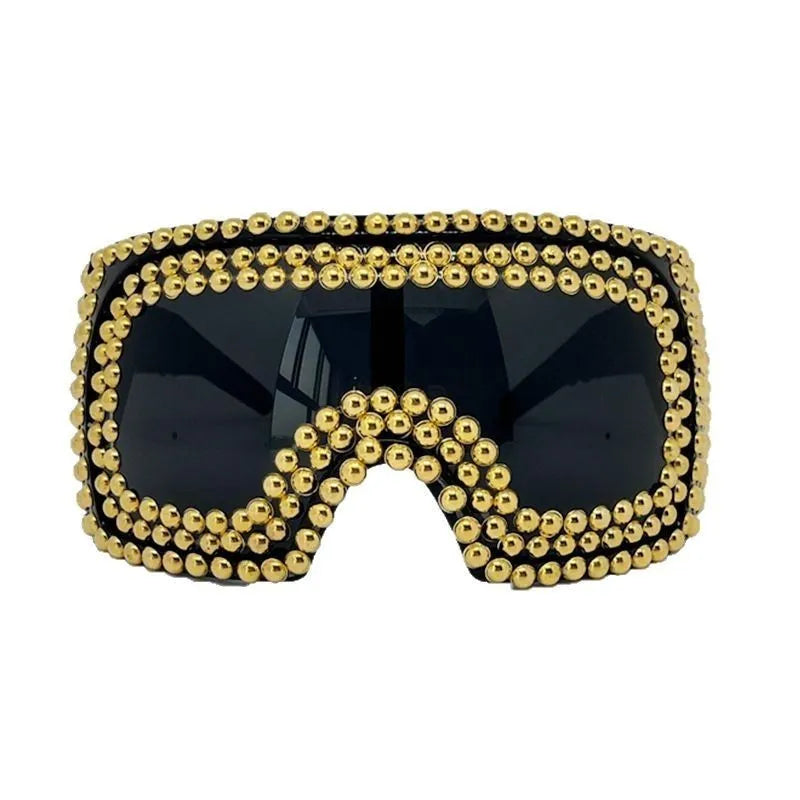 Square punk sunglasses with large rim and rivet detailing in gold colour