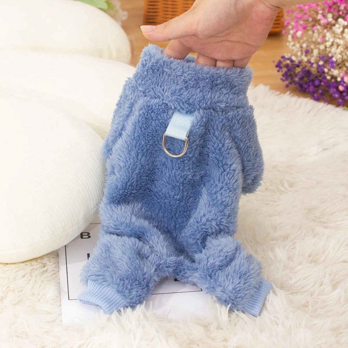 Blue double-sided plush four-legged dog clothing with high collar and towing ring laid flat.