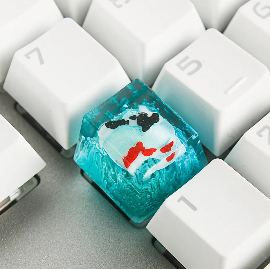 Close-up of a custom resin keycap featuring a detailed blue and orange koi fish scene, designed for Cherry MX mechanical keyboards.