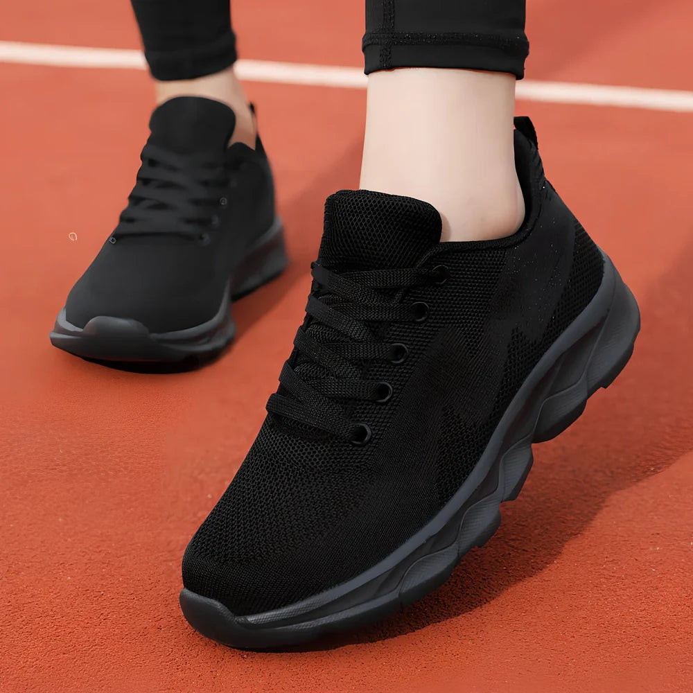 Women's black sneakers with mesh upper, wedge heel, and lace-up front