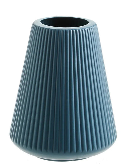 Melamine plastic decorative vase in blue colour measuring 16cm by 20cm on wooden desk