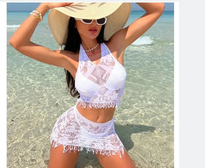 Women's white two-piece swimsuit with lace bikini top and tassel skirt on beach