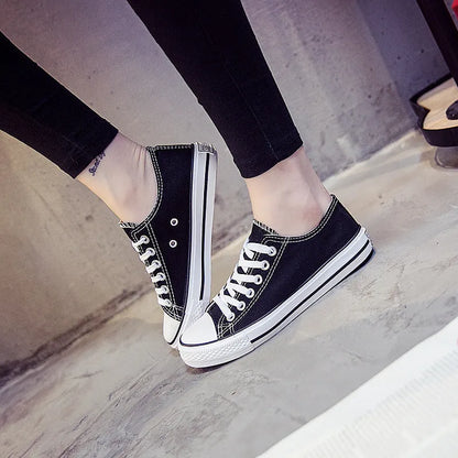 Women's solid colour canvas plimsoll shoes on a white background, showcasing lace-up design and rounded toe.