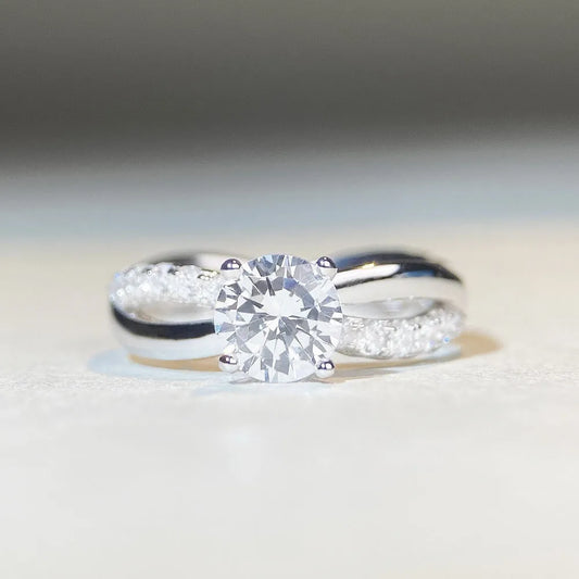 Geometric silver ring with 1 karat moissanite centre stone in four-claw setting and twisted arm band design