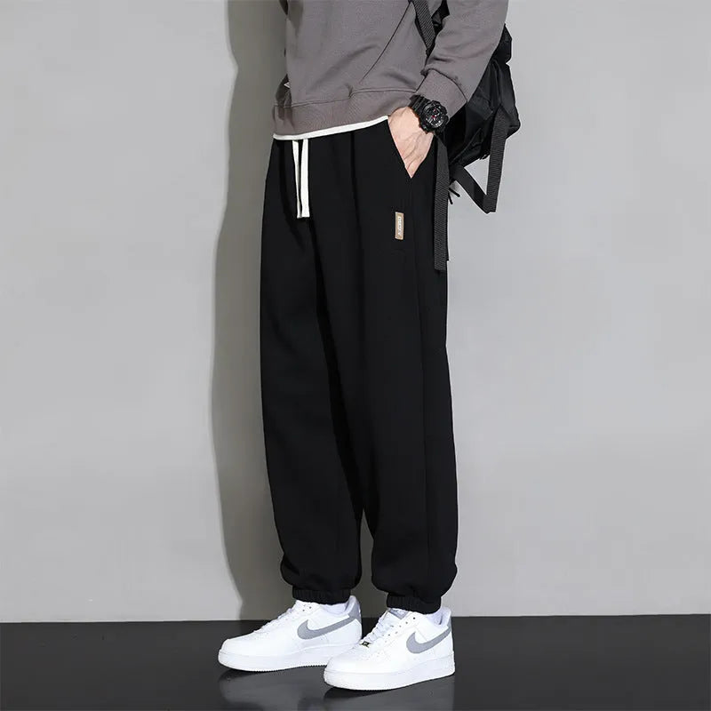 Men's loose gray casual sports trousers with drawstring waist on a hanger