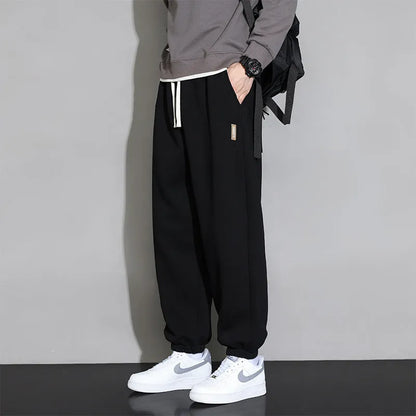 Men's loose gray casual sports trousers with drawstring waist on a hanger