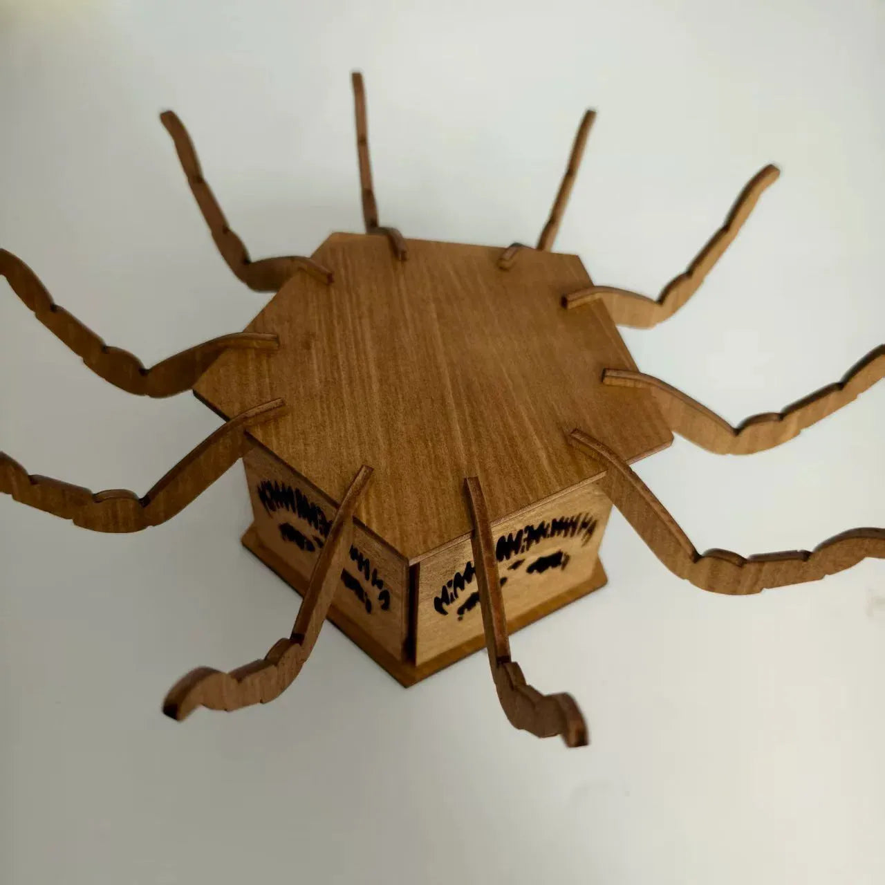 Dark stained wooden lantern candlestick with carved spiderweb design, holding a white taper candle.