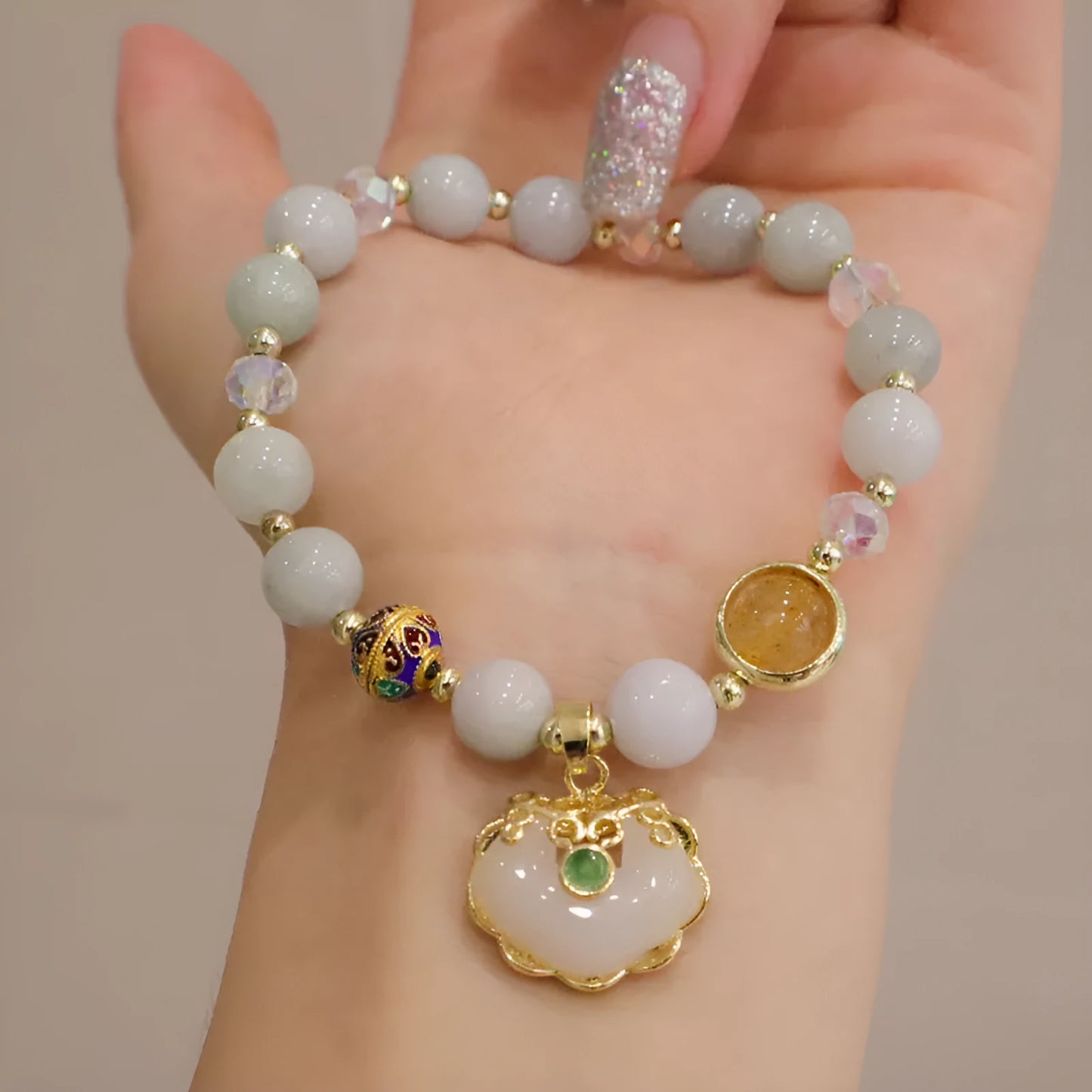 Geometric ethnic style jade bracelet for women with metal charm decoration in gray or strawberry quartz.