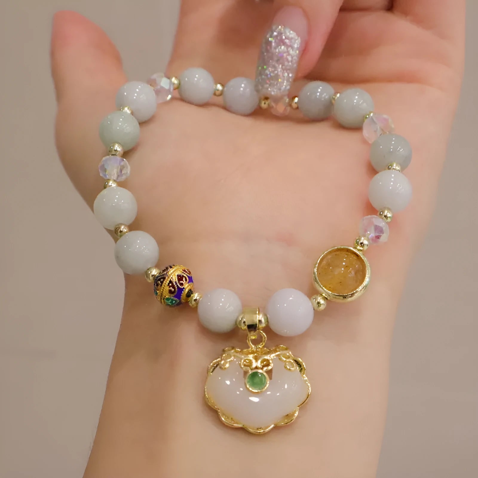 Geometric ethnic style jade bracelet for women with metal charm decoration in gray or strawberry quartz.