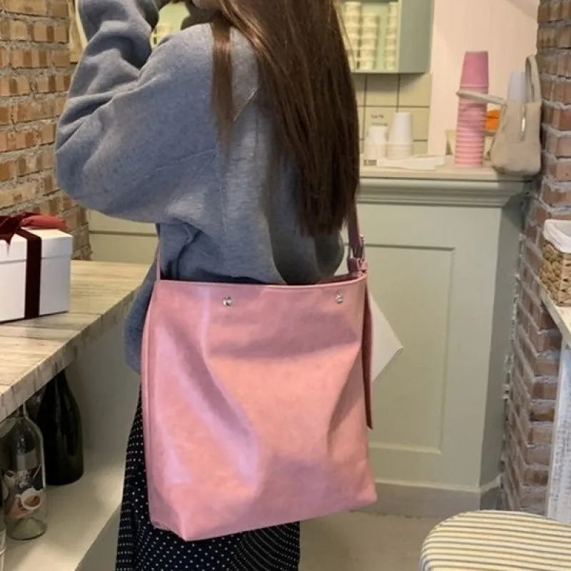 Pink corduroy one-shoulder bag showing its textured fabric and single strap.