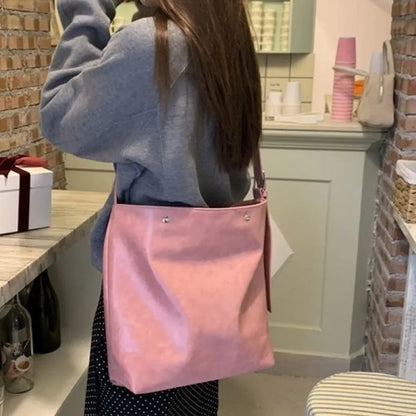 Pink corduroy one-shoulder bag showing its textured fabric and single strap.
