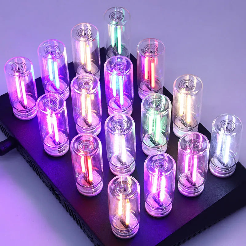 Small transparent glass USB touch night lamp with warm white light on a surface.