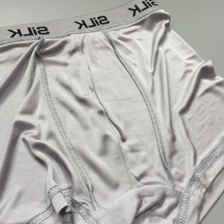 Men's loose-fitting silk shorts in navy blue on a neutral background.