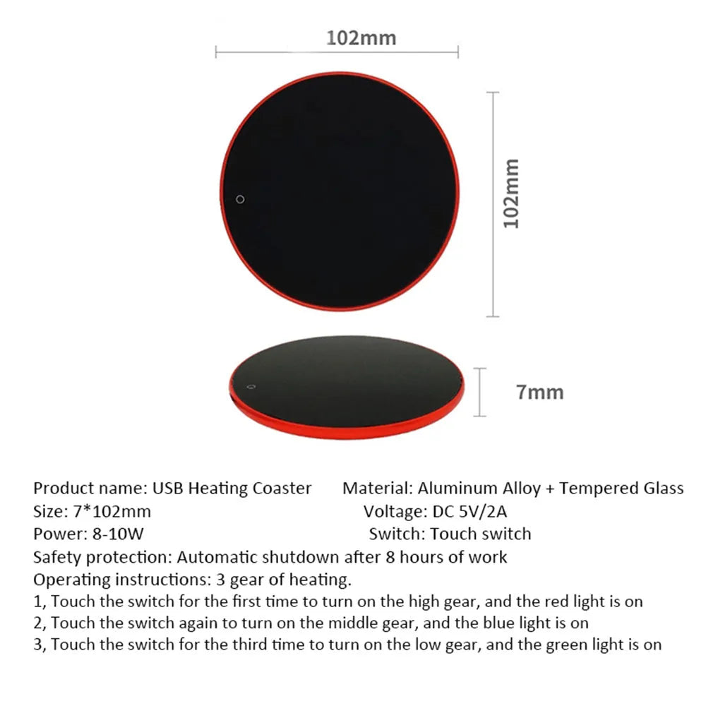 Black USB heating coaster on a desk next to a coffee mug, showing touch controls and coloured indicator light.
