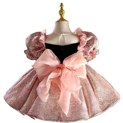 Pink children's princess dress with cute design elements, shown on hanger