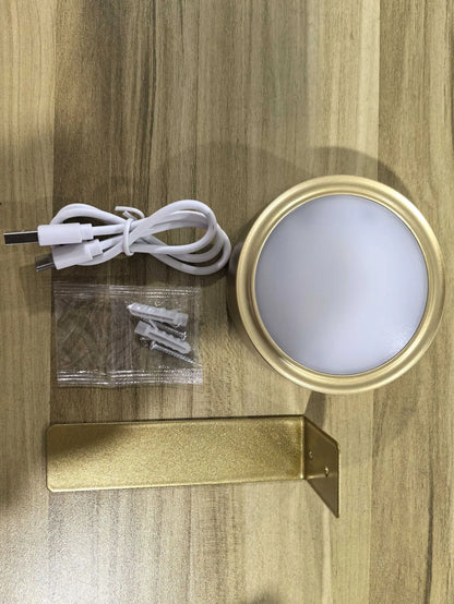 Black magnetic LED painting lamp with remote control on a white wall.
