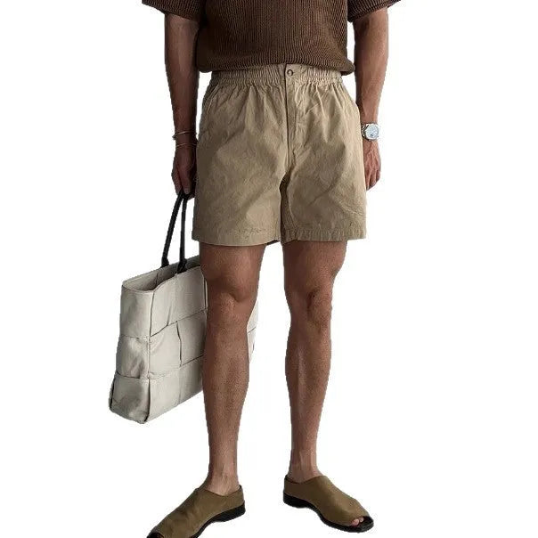 Men's loose-fit cotton sports shorts in black, shown on a hanger