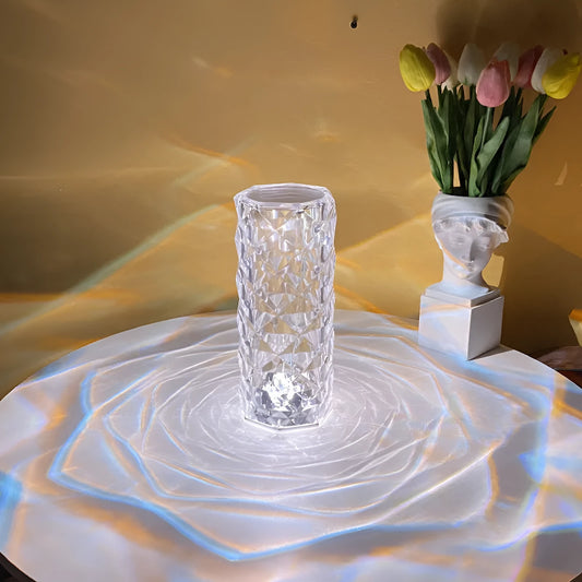 Modern minimalist acrylic crystal rose LED table lamp with touch switch on a wooden table.