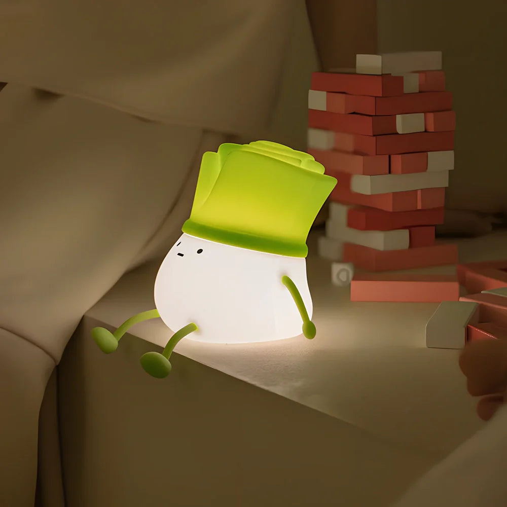 Green onion-shaped night light with warm white glow on desktop, showing 125mm width and flower design