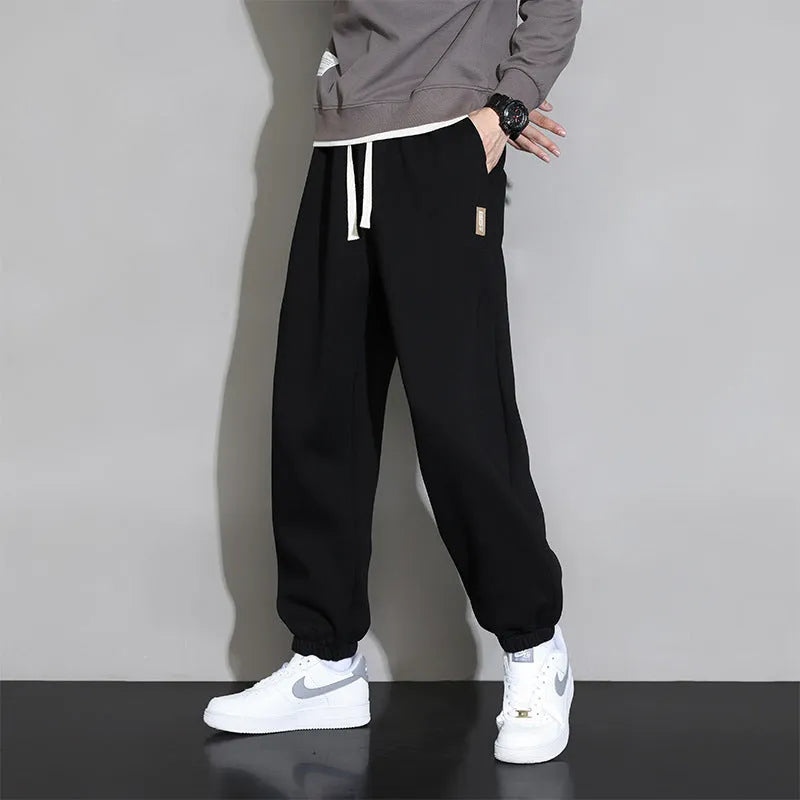 Men's loose gray casual sports trousers with drawstring waist on a hanger