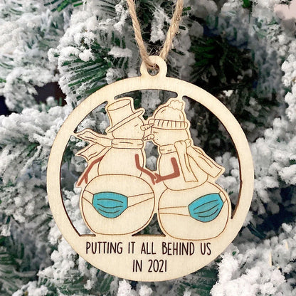 Wooden hollowed-out Christmas ornament with intricate snowman and deer laser-cut design